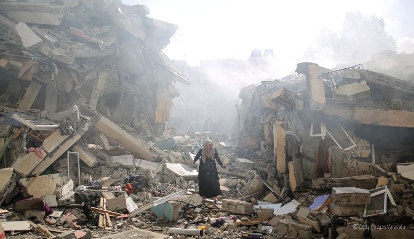 Nainen kävelee asuinrakennusten raunioiden keskellä Israelin ilmaiskujen jälkeen al-Zahran kaupunginosassa Gazan kaistalla 19. lokakuuta 2023. 