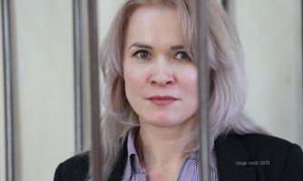 Maria Ponomarenko katsoo kaltereiden läpi suoraan kohti kameraa.