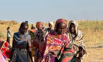 Ihmiset kävelevät hiekkatiellä.