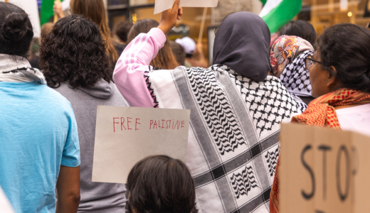 Lapsi ja aikuinen mielenosoituksessa. Lapsen kyltissä lukee Free Palestine, naisella on valkomustakuvioinen palestiinahuivi.