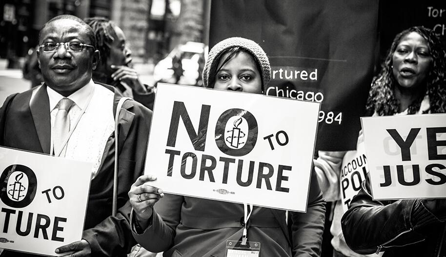 Mielenosoittajat pitävät "no to torture"-kylttejä
