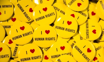 Lähikuva rintamerkeistä. Rintamerkeissä on teksti: I love human rights.