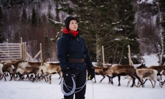 Maja Kristine Jåma seisoo porolauman edessä.
