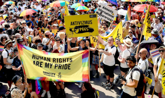 Joukko ihmisiä osoittamassa mieltä. Osa heistä kantaa banderollia, jossa lukee "Human rights are my pride".